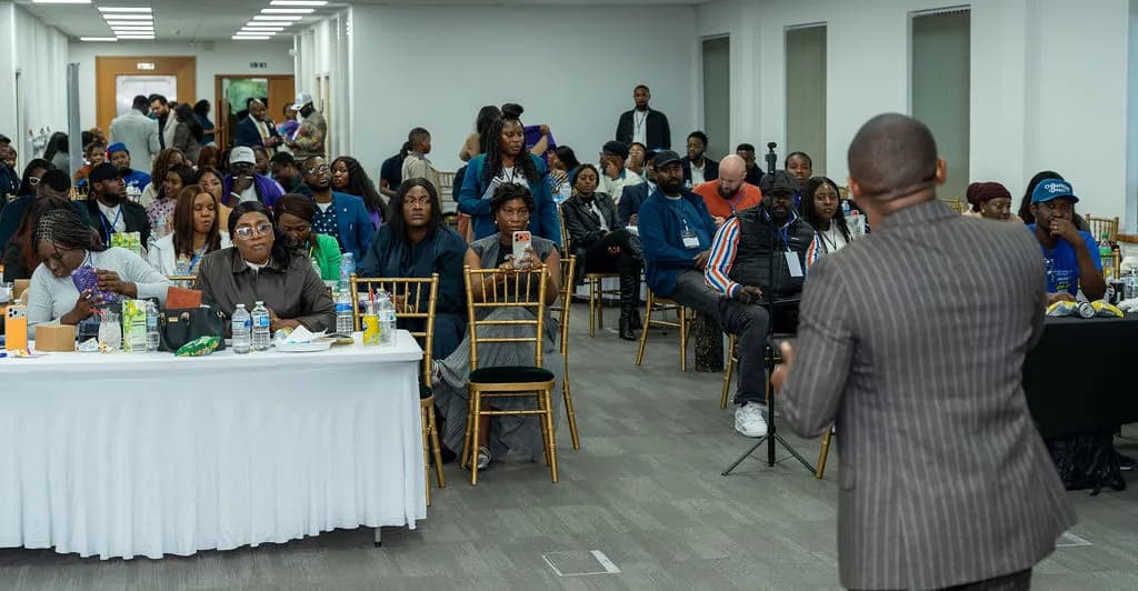 A speaker addressing a full room of seated attendees
