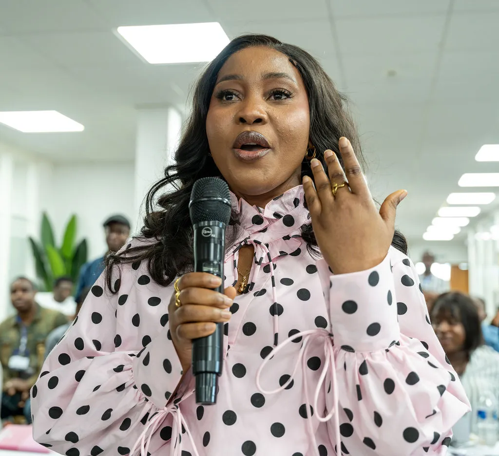An attendee speaking animatedly into a microphone from the audience