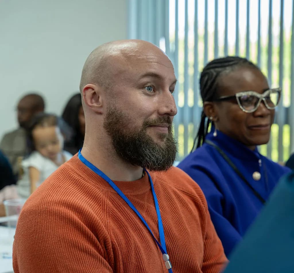 Two attendees smiling as they listen to a session