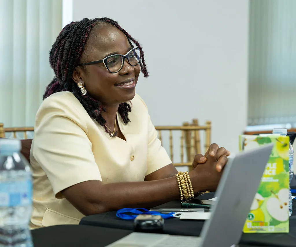 An attendee smiling warmly at a laptop during a session