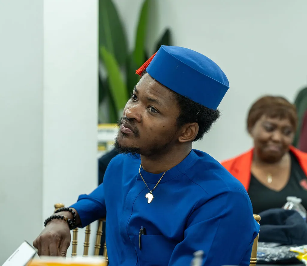 An attendee in a blue cap listening intently