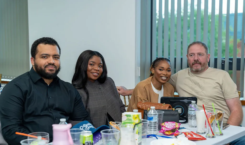 Four attendees smiling together at a table